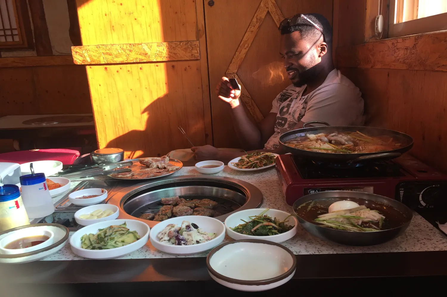 Solo traveler surrounded by Korean food dishes, capturing the abundance of culinary experiences in Seoul