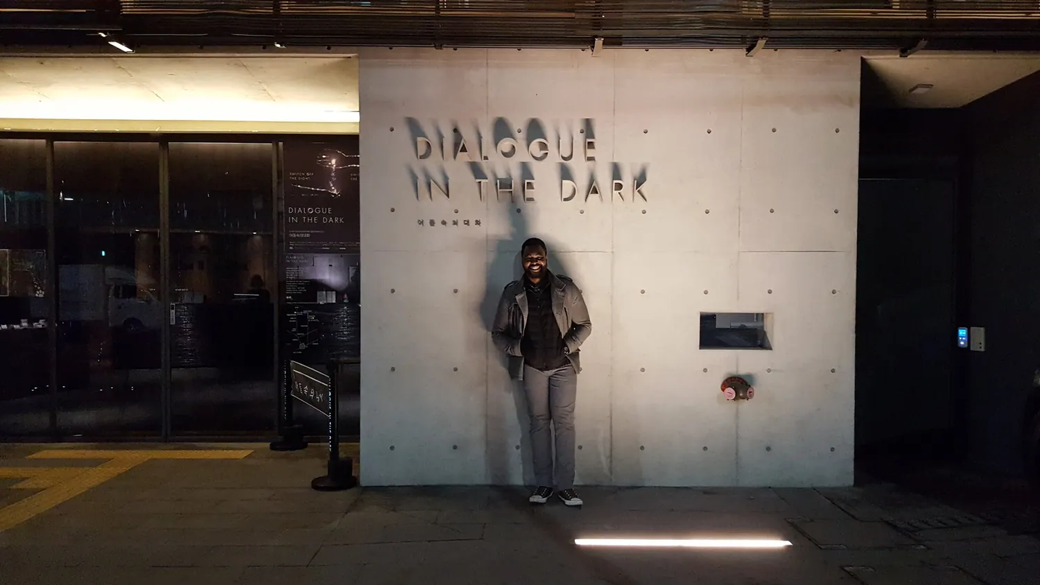 Traveler standing in front of Dialogue in the Dark exhibition entrance