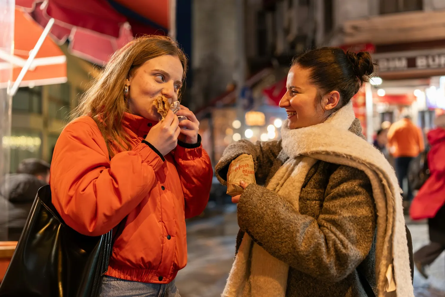 two travelers sharing a meal at a street food stall
